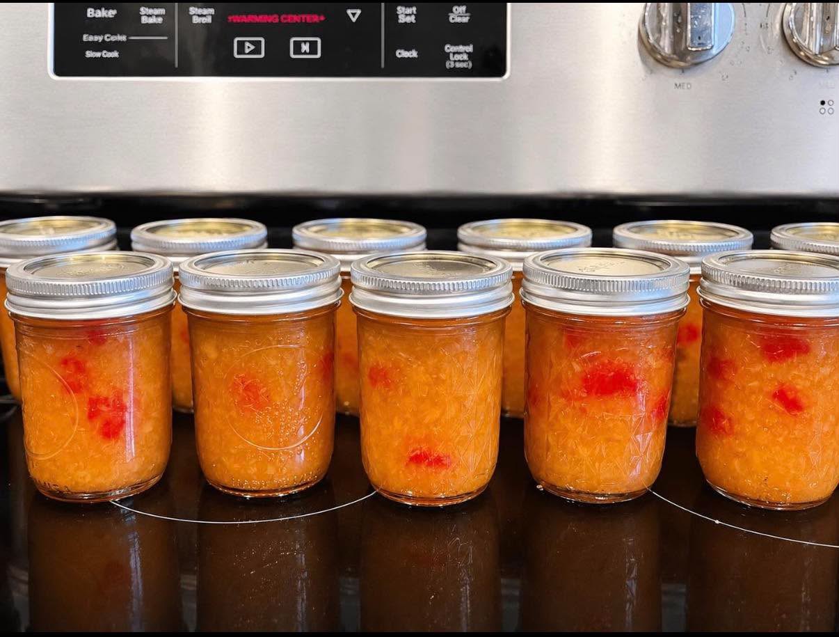 A fresh batch of golden preserves with red fruit pieces